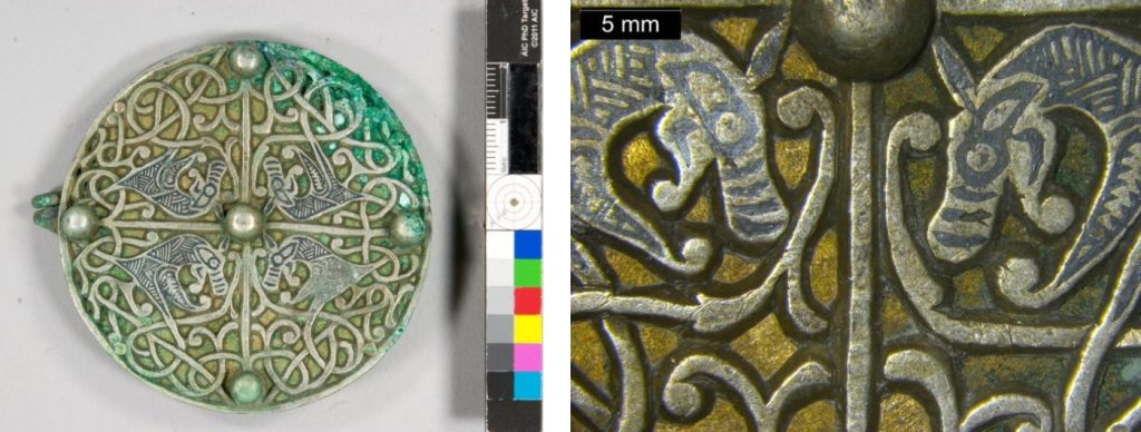 Side-by-side look at the front of the circular brooch before conservation laid on a white surface next to a ruler, and a closeup of two of the beasts on the brooch facing each other. They resemble dogs or wolves.